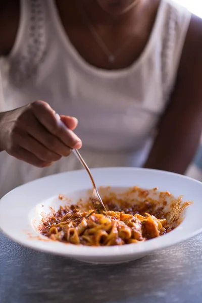 Seorang wanita muda Afrika-Amerika makan pasta — Stok Foto