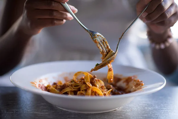 Seorang wanita muda Afrika-Amerika makan pasta — Stok Foto