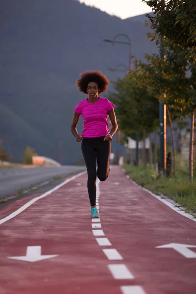 Una joven afroamericana corriendo al aire libre — Foto de Stock