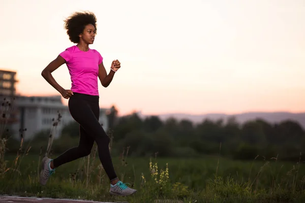 Una joven afroamericana corriendo al aire libre — Foto de Stock