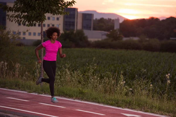 Een jonge African American vrouw buitenshuis joggen — Stockfoto