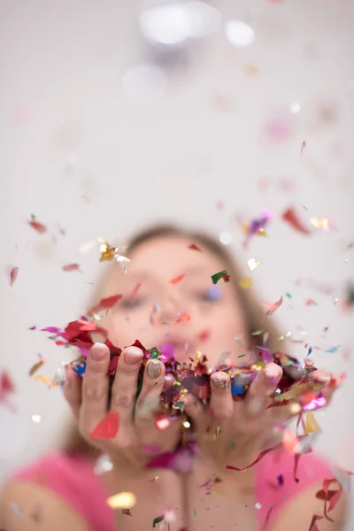 Woman blowing confetti in the air — Stock Photo, Image