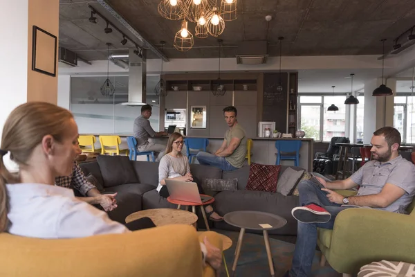 現代オフィスの若者グループはノートパソコンやコーヒーを飲みながらチームミーティングやブレインストーミングをしています — ストック写真