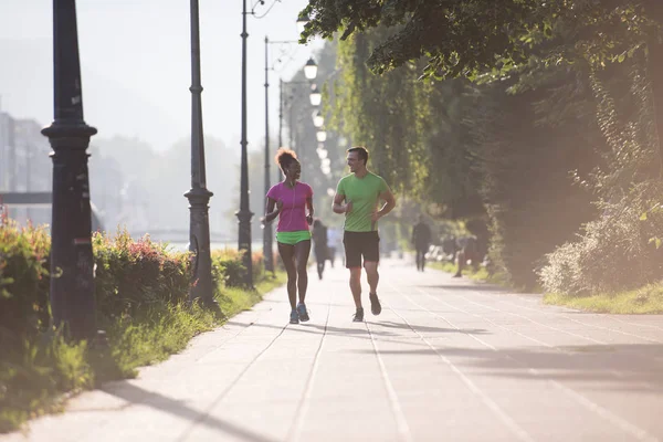 Jeune couple multiethnique jogging dans la ville — Photo