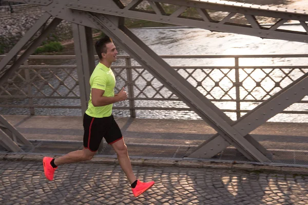 Een jonge man joggen in de stad — Stockfoto