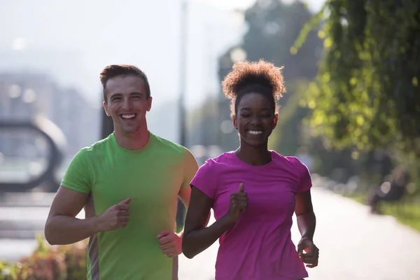 Jonge multi-etnisch paar joggen in de stad — Stockfoto