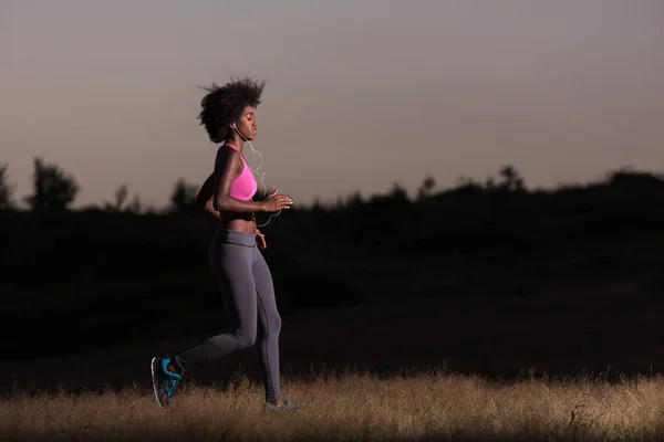 Young African american woman jogging in nature — Stock Photo, Image