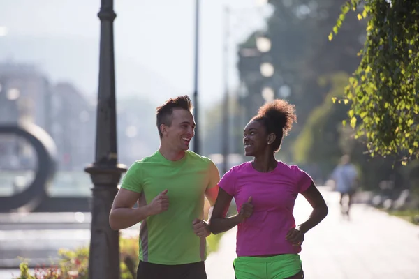 Young multiethnic couple jogging in the city — Stock Photo, Image