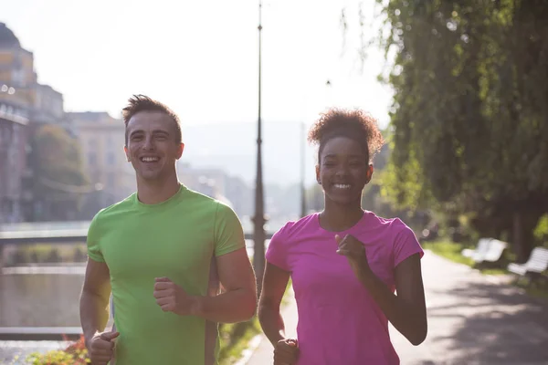 Junges multiethnisches Paar joggt in der Stadt — Stockfoto