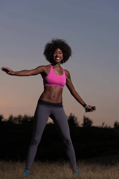 Negro mujer está haciendo estiramiento ejercicio relajante y calentar — Foto de Stock