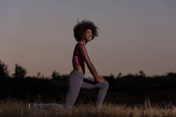黒人女性はリラックスしてウォーム アップのストレッチ運動をやっています。 — ストック写真