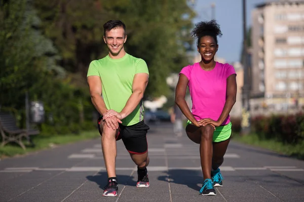 Jogging par uppvärmning och stretching i staden — Stockfoto