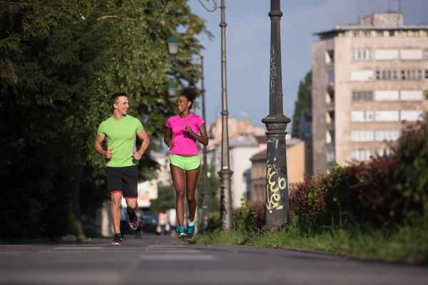 Ung leende multietniskt par jogging i staden — Stockfoto