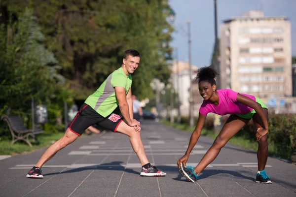 Jogging par uppvärmning och stretching i staden — Stockfoto