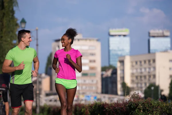 Jeune souriant couple multiethnique jogging dans la ville — Photo