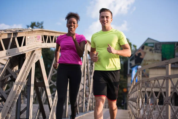 Multiethnisches Paar joggt in der Stadt — Stockfoto