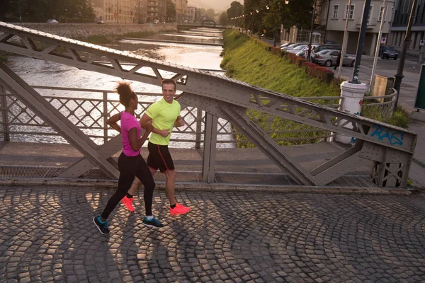 Jeune couple multiethnique jogging dans la ville — Photo