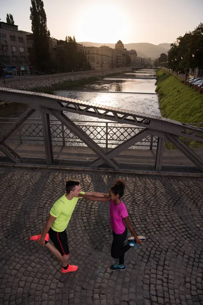Correndo casal aquecimento e alongamento na cidade — Fotografia de Stock