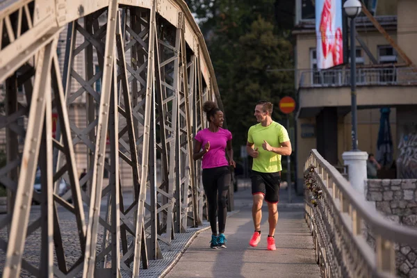 多民族のカップルを街でジョギング — ストック写真