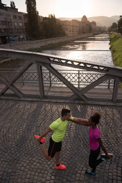 Jogging coppia riscaldamento e stretching in città — Foto Stock