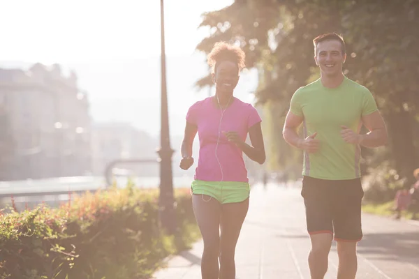 Young multiethnic couple jogging in the city — Stock Photo, Image