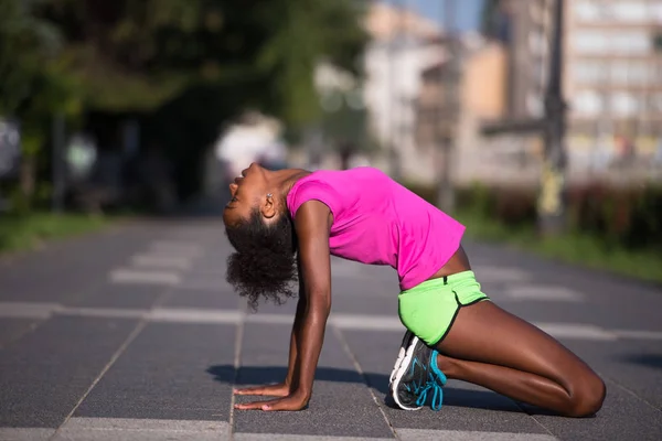 Спортивна молода афроамериканська жінка розтягується на відкритому повітрі — стокове фото