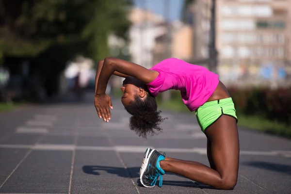 Deportivo joven africano americano mujer estiramiento al aire libre — Foto de Stock