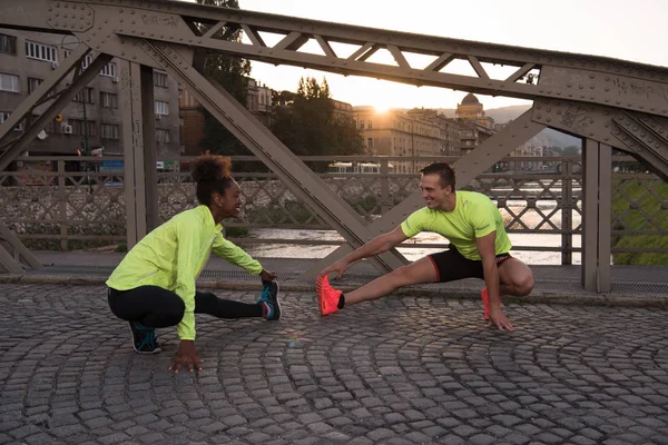 Jogging couple échauffement et étirement dans la ville — Photo