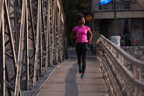 Donna afro-americana che corre attraverso il ponte — Foto Stock