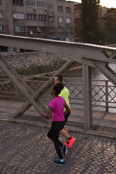 Jovem casal multiétnico correndo na cidade — Fotografia de Stock