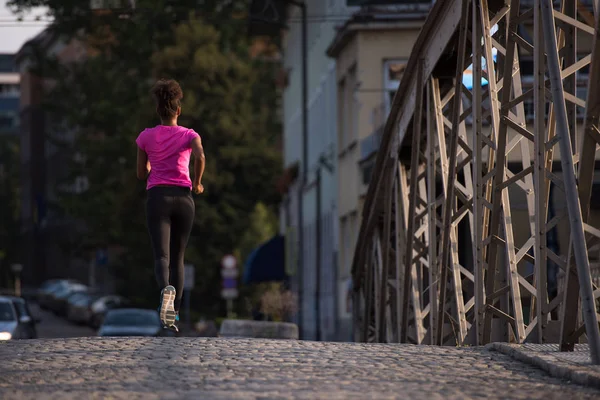 Africká americká žena běží přes most — Stock fotografie