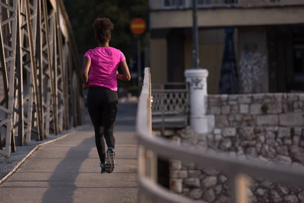 Donna afro-americana che corre attraverso il ponte — Foto Stock