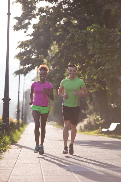 Jovem casal multiétnico correndo na cidade — Fotografia de Stock