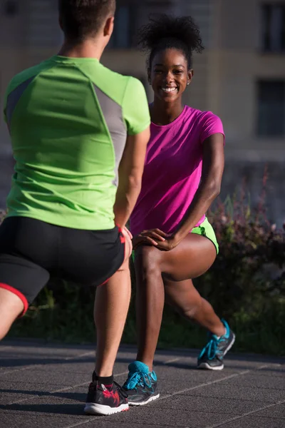 Jogging par uppvärmning och stretching i staden — Stockfoto