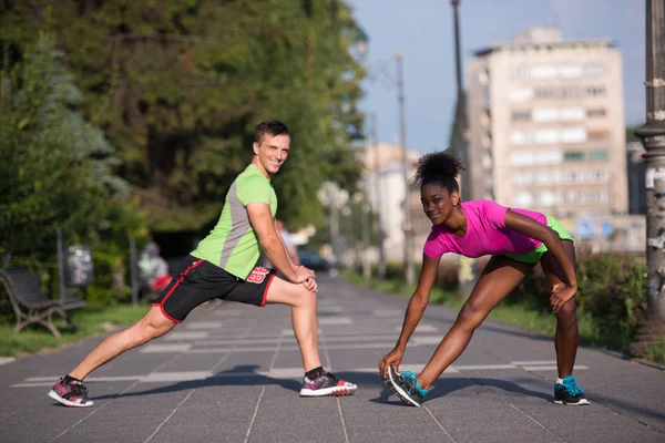 Jogging couple échauffement et étirement dans la ville — Photo