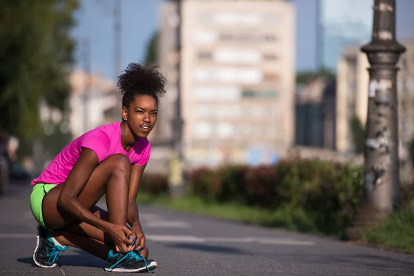 Mujer afroamericana corredor apretando zapato encaje — Foto de Stock