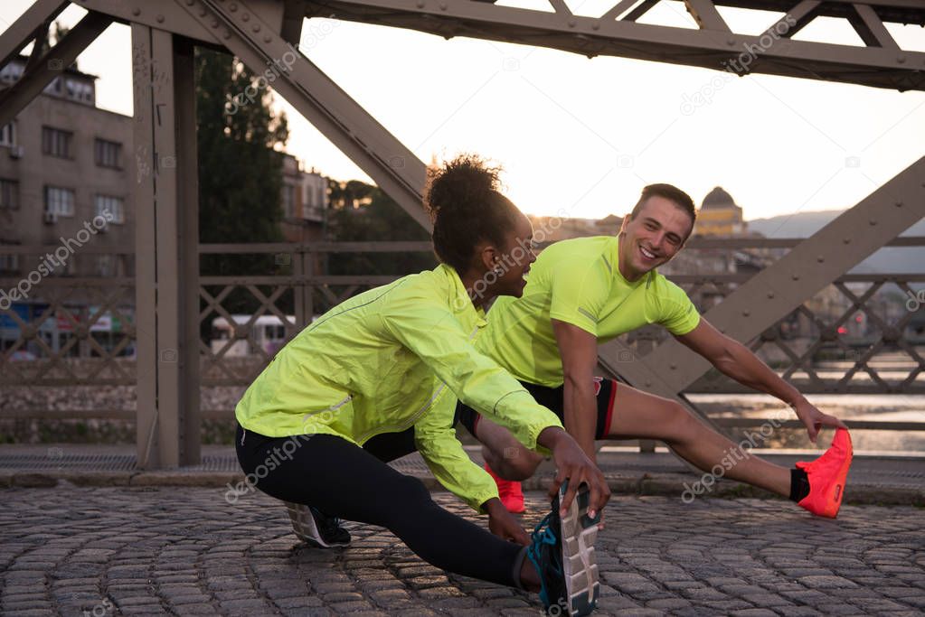 jogging couple warming up and stretching in the city