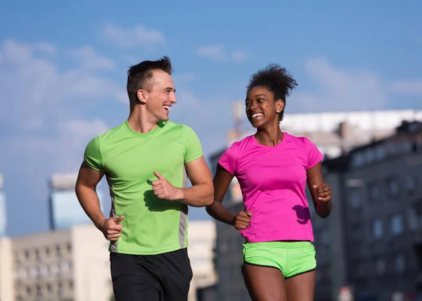 Junges lächelndes multiethnisches Paar beim Joggen in der Stadt — Stockfoto