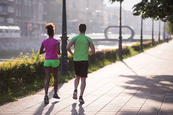 Jeune couple multiethnique jogging dans la ville — Photo