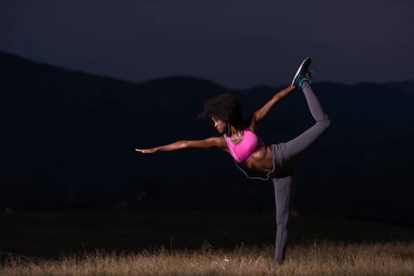 black woman doing yoga  in the nature