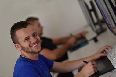 Dijital tablet ve bilgisayar üzerinde çalışan genç grafik tasarımcısı