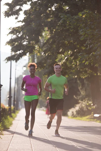 Junges multiethnisches Paar joggt in der Stadt — Stockfoto