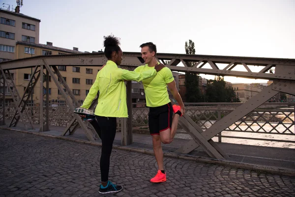 Joggingpaar wärmt und dehnt sich in der Stadt — Stockfoto