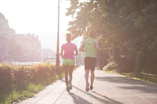 Jonge multi-etnisch paar joggen in de stad — Stockfoto
