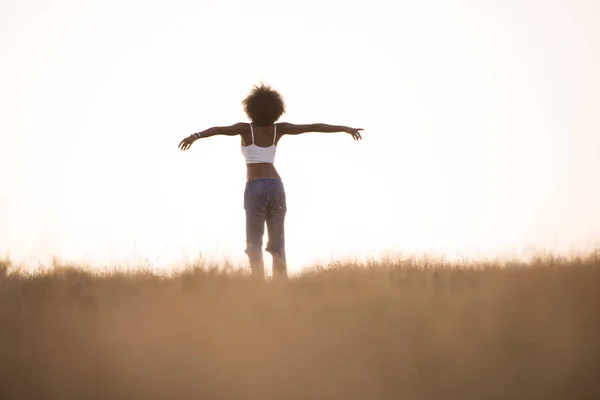 Jovem menina negra dança ao ar livre em um prado — Fotografia de Stock