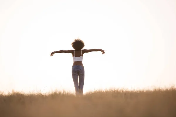 Young black girl dances outdoors in a meadow — Stock Photo, Image