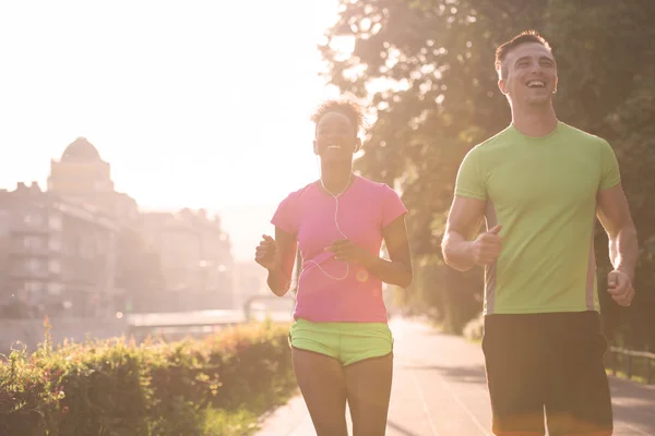 Jonge multi-etnisch paar joggen in de stad — Stockfoto