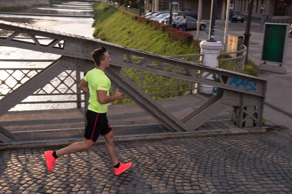 Un jeune homme qui fait du jogging en ville — Photo