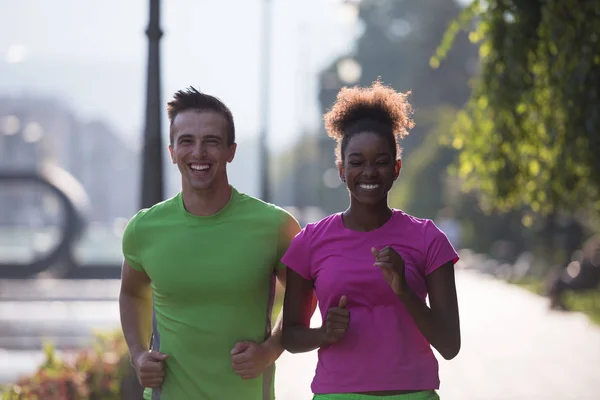 Jonge multi-etnisch paar joggen in de stad — Stockfoto