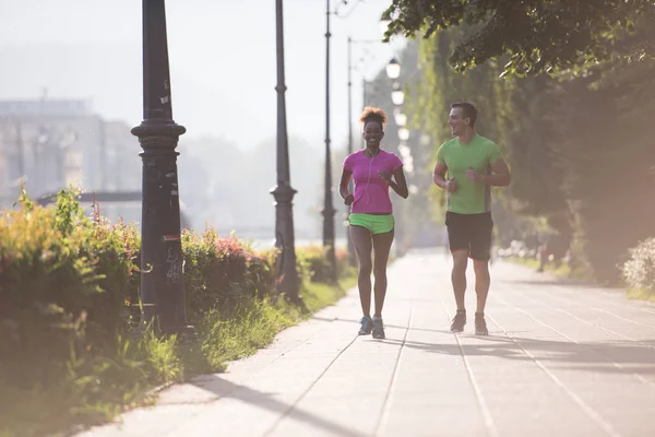 Unga multietniskt par jogging i staden — Stockfoto